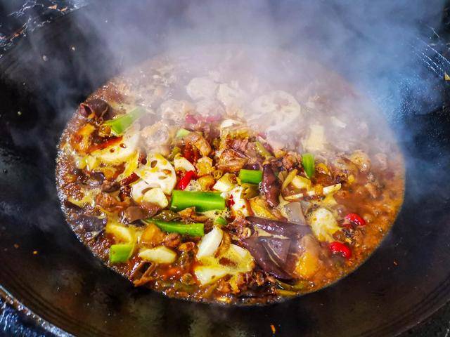 铁锅里的鸡肉和各种各样的菜混在一起正冒着热气,闻起来香喷喷的,一看