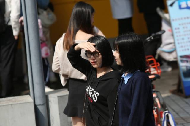 3月2日,深圳东门步行街,用手遮雨的女子.