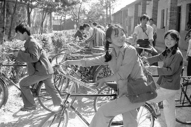 80年代中国珍贵历史老照片:图为骑着自行车,背着挎包上学的学生们.