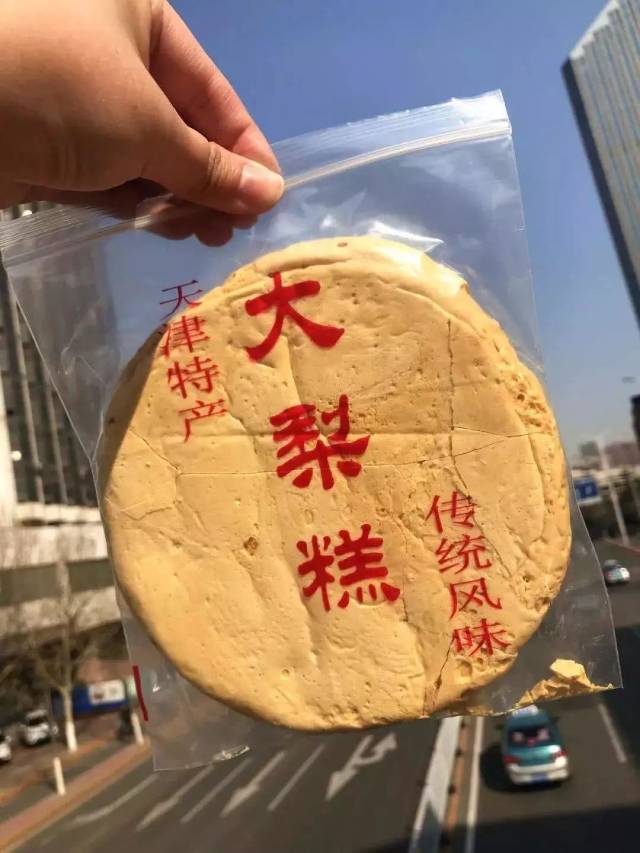 大梨糕黄黄脆脆的,一个大圆形,有脸那么大,也许是糖熬制得有点过火,吃