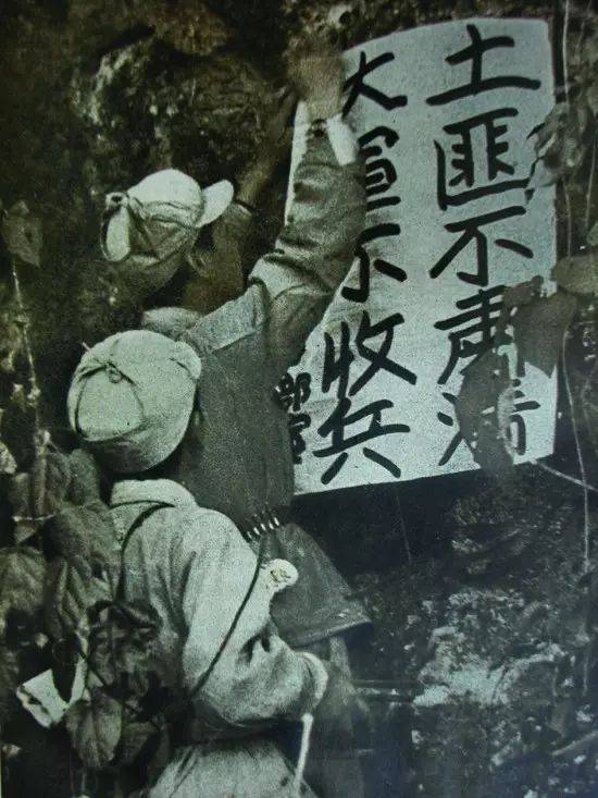 1950年,解放军战士在张贴剿匪宣传单:土匪不肃清,大军不收兵.