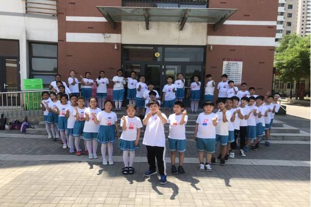 学生在学校操场上摆出各种新颖造型,拍摄了毕业照,为自己的小学生活留