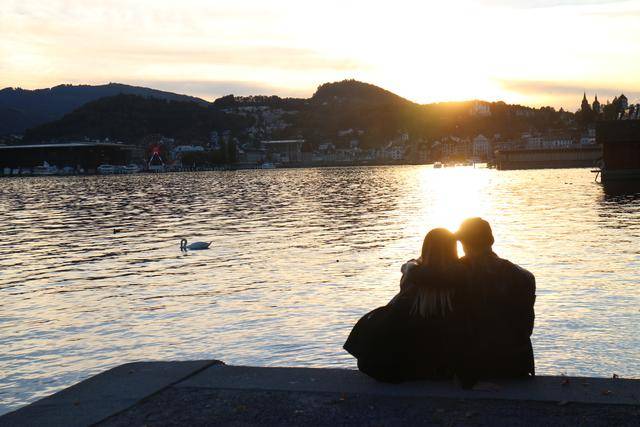 夕阳西下,一对恋人依偎在卢塞恩湖畔,享受爱情和小城的美好