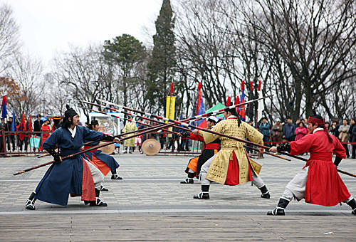 资料图:在韩国首尔市中心的南山,市民和游客观看传统武术表演.