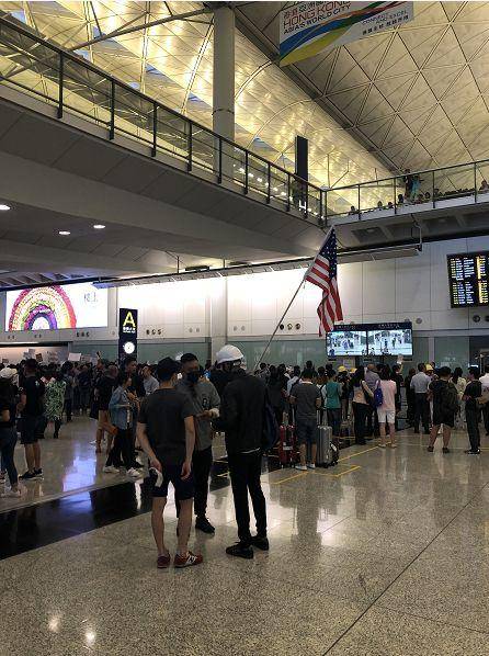 真荒唐!反对派滋扰香港机场误导旅客,还有人打出美国旗