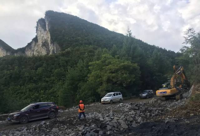 339省道建始官店至鹤峰邬阳段公路工程现场,机器轰鸣,一派忙碌景象.