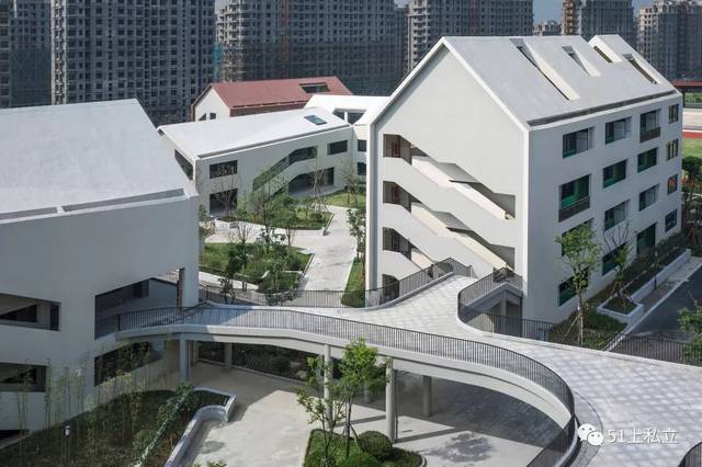 学校建筑将8000多平方米的体量打散成15个坡屋顶小房子,依照幼儿园