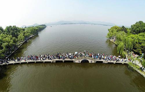 图为5月1日,杭州西湖景区里的游客熙熙攘攘.图片来源:新华社