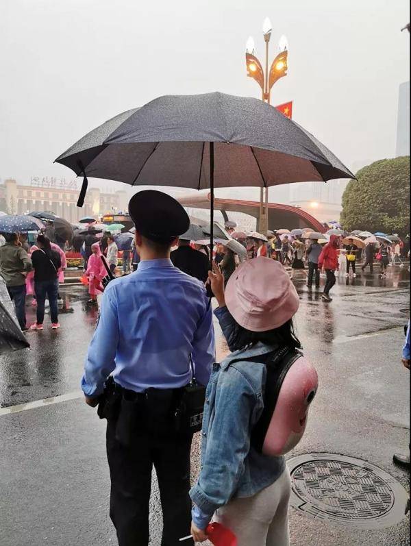 成都天府广场暖心一幕:市民自发为执勤民警撑伞