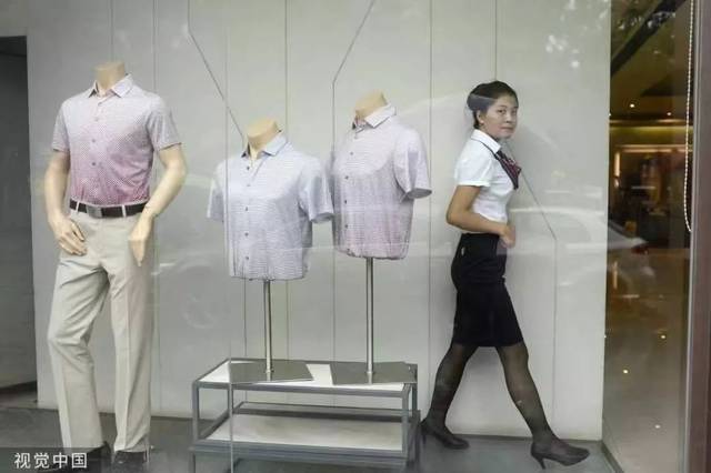 2001年,一位服务员正走过商场的男装专柜.