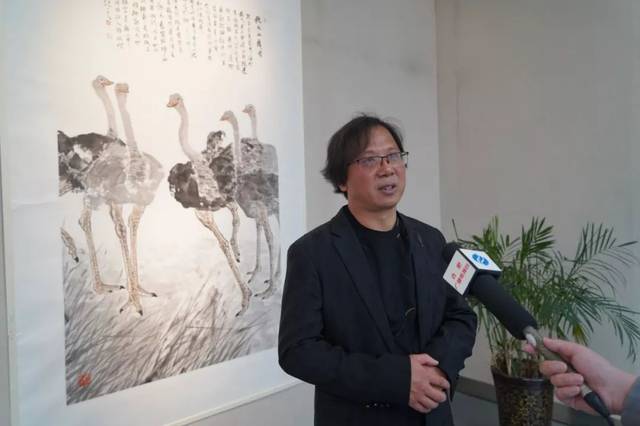 画家李小龙在展厅接受媒体采访