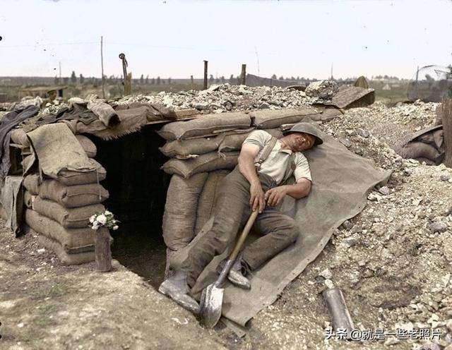 一战期间,一名刚挖完战壕疲惫不堪的英军士兵在掩体外面熟睡.