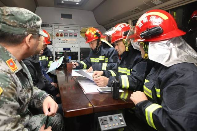 临时指挥所里,消防指挥员对火场救援力量进行分析部署