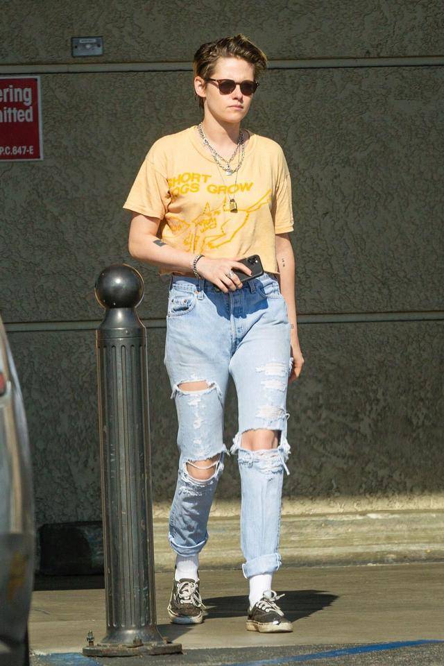 女星克里斯汀·斯图尔特(kristen stewart)穿着破洞牛仔裤配黄半袖