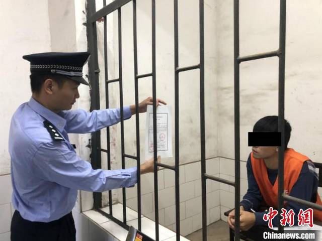 图为缉私民警向走私香烟的犯罪嫌疑人出示逮捕证 王淑艳 摄中新网