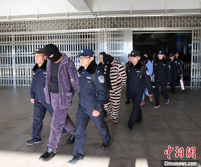 民警押解犯罪嫌疑人走出火车站. 杨文涛 摄