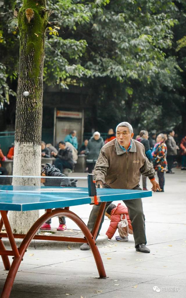 广场乒乓球台上,生龙活虎的大爷正"教训"着玩不好国粹运动的后辈