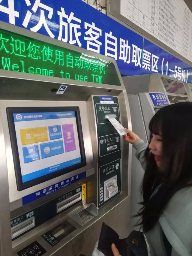 记者来到邵阳火车站售票厅 乘客在取票机前用身份证操作取票 出来的