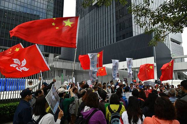 参加请愿的香港市民挥舞国旗和区旗.