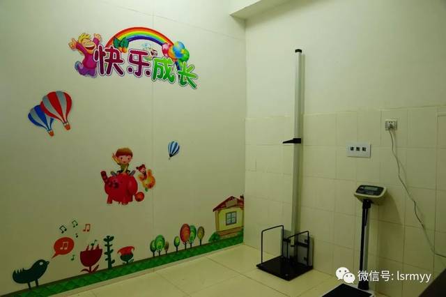 儿保门诊),张贴着色彩缤纷的卡通图案墙画,诊室内空调开放着十分温馨
