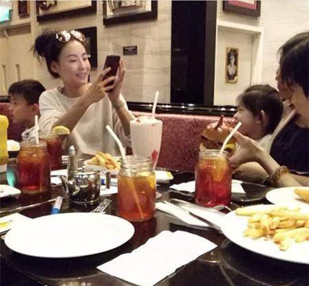 图为张柏芝带儿子们一起吃饭画面,张柏芝还不忘拍照留念