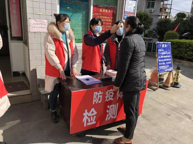 三福小区路口,三福花园门口"防疫体温检测点"巾帼志愿者为居民测量