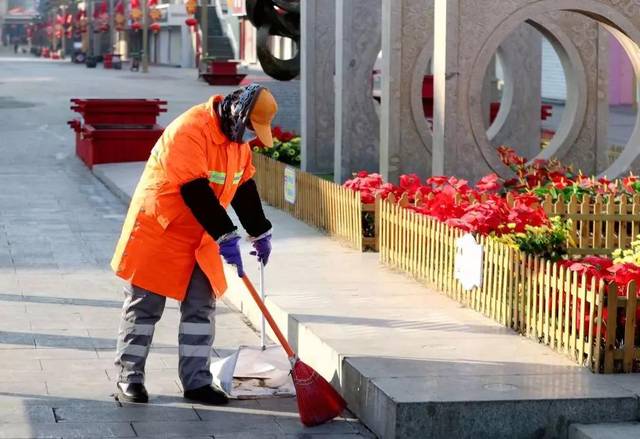 一位环卫工人在认真清扫无人的街道