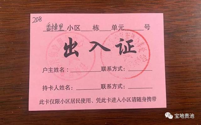 小区大门口向社区居民发放自制的"临时出入证,有了这张简易的通行