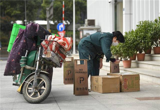 3月20日,湖北省武汉市洪山区珞喻路,中国邮政快递员在送货.