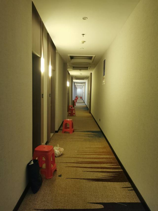酒店走廊,每天的隔离餐会放在房间门口摆放的红凳子上.受访者供图