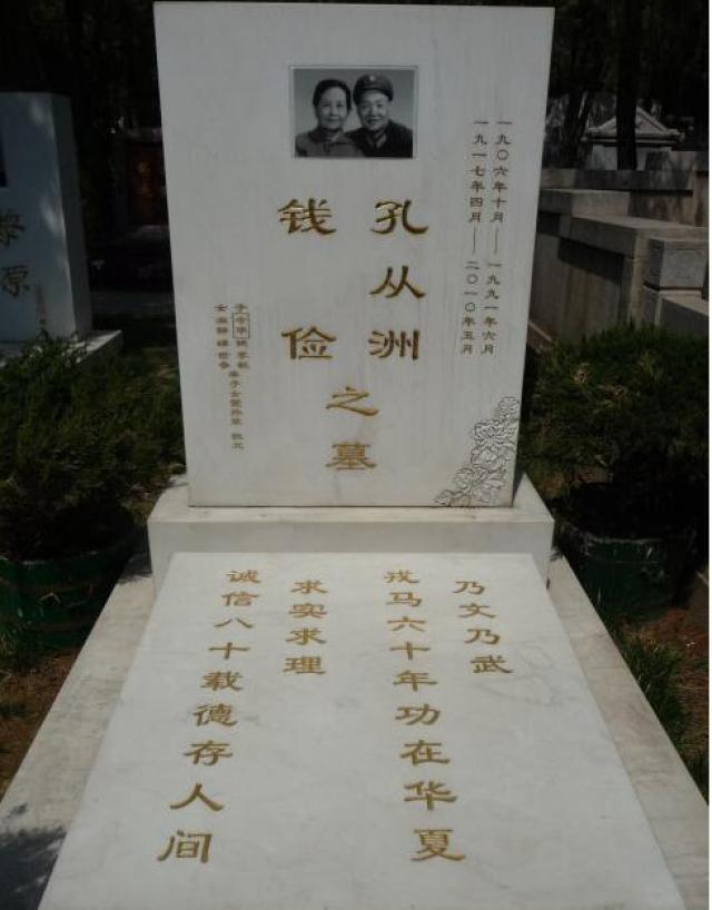 这是他和夫人的合葬墓,洁白的墓碑上面是夫妻两人的遗像,周围松柏鲜花