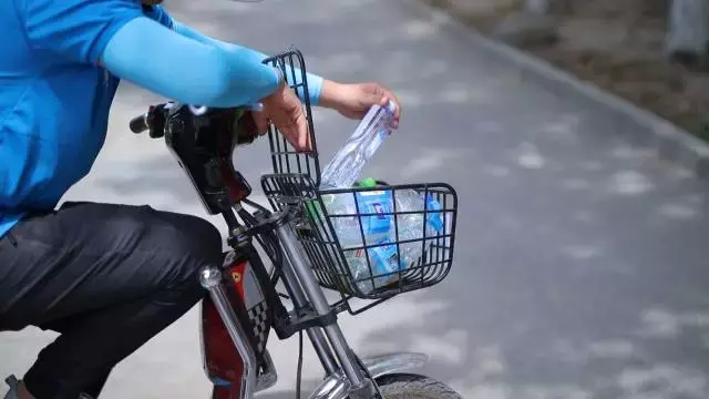 烈日下送餐,阿斯力汗停在路边大口地喝水 在这跑单,可能要喝掉平时2