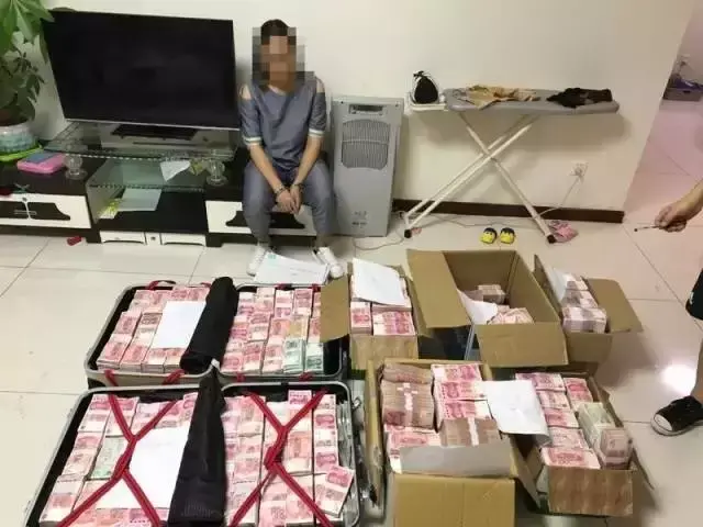 警方查获5个装钞票的箱子,另外两个行李箱内顶部和底部全都装满了现金