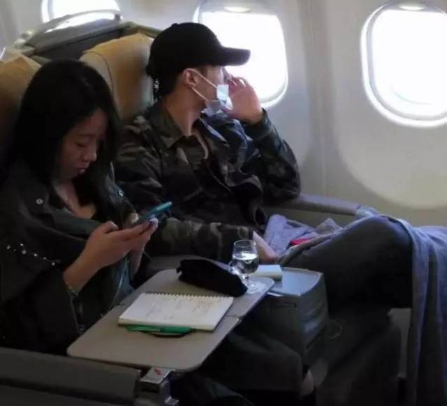 图中张艺兴和助理在飞机上的画面,张艺兴看起来很疲惫!