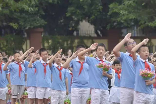 小学生 镜头三 :升旗仪式 全体立正,出旗,奏乐,升国旗,奏唱国歌,敬礼