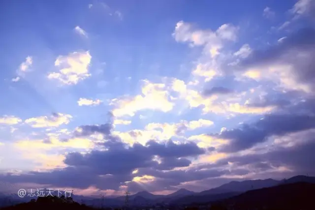 太阳正好从西边的"双乳峰"落山,阳光透过地平线射到上面的云,才有了
