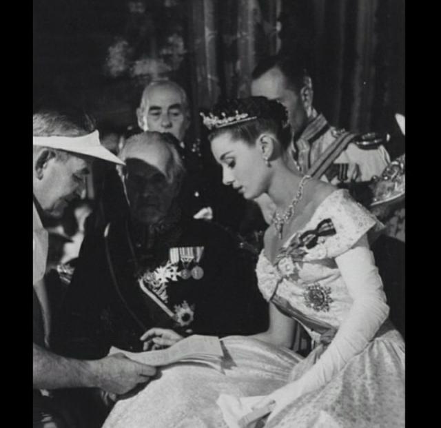 奥黛丽·赫本在电影《罗马假日》中,公主穿的晚礼服上,戴着数枚胸针.