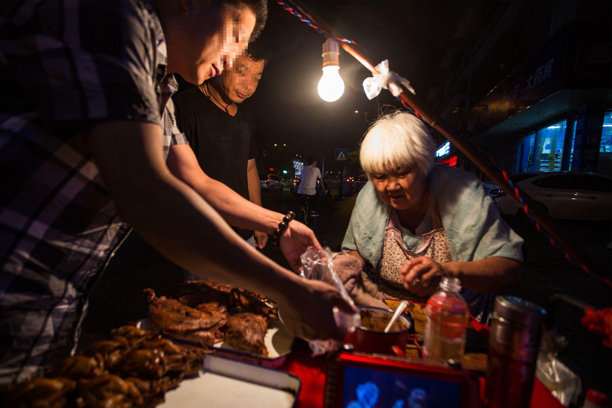 银发老太深夜摆摊卖中药狗肉剩肉喂狗