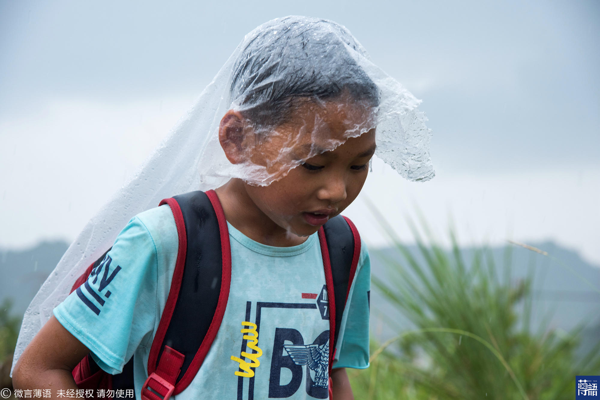 也淋湿了他胸前的衣服,但是孩子还是坚定的在雨中奔跑着