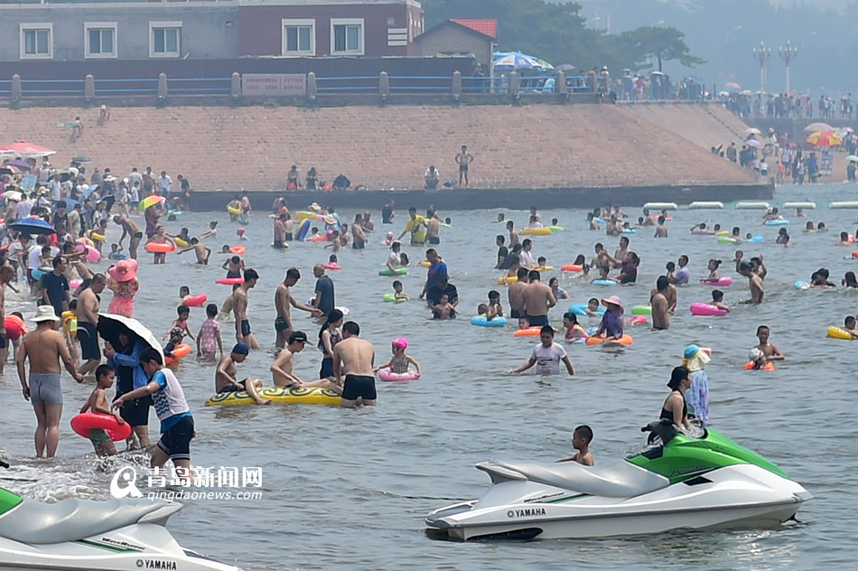 7月20日,青岛栈桥海水浴场上游客爆满
