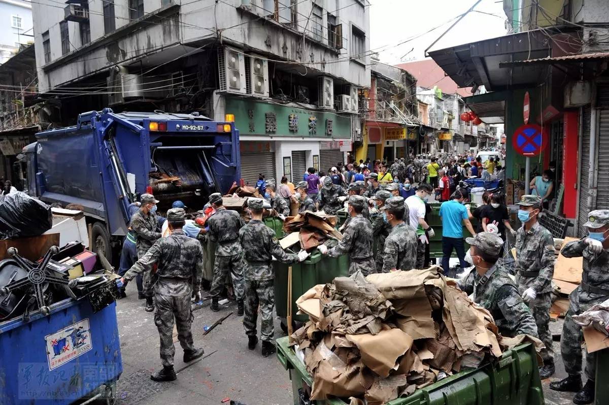 看到子弟兵清理被海水浸泡過的雜物垃圾,市民拿出口罩遞給官兵,有的還