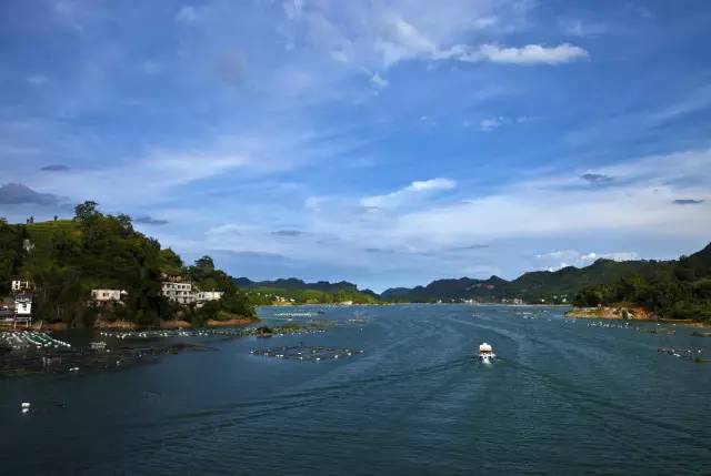 白天,湛藍的天與青山碧水相互映襯,兩岸風景如畫,描繪出湖天一色之景