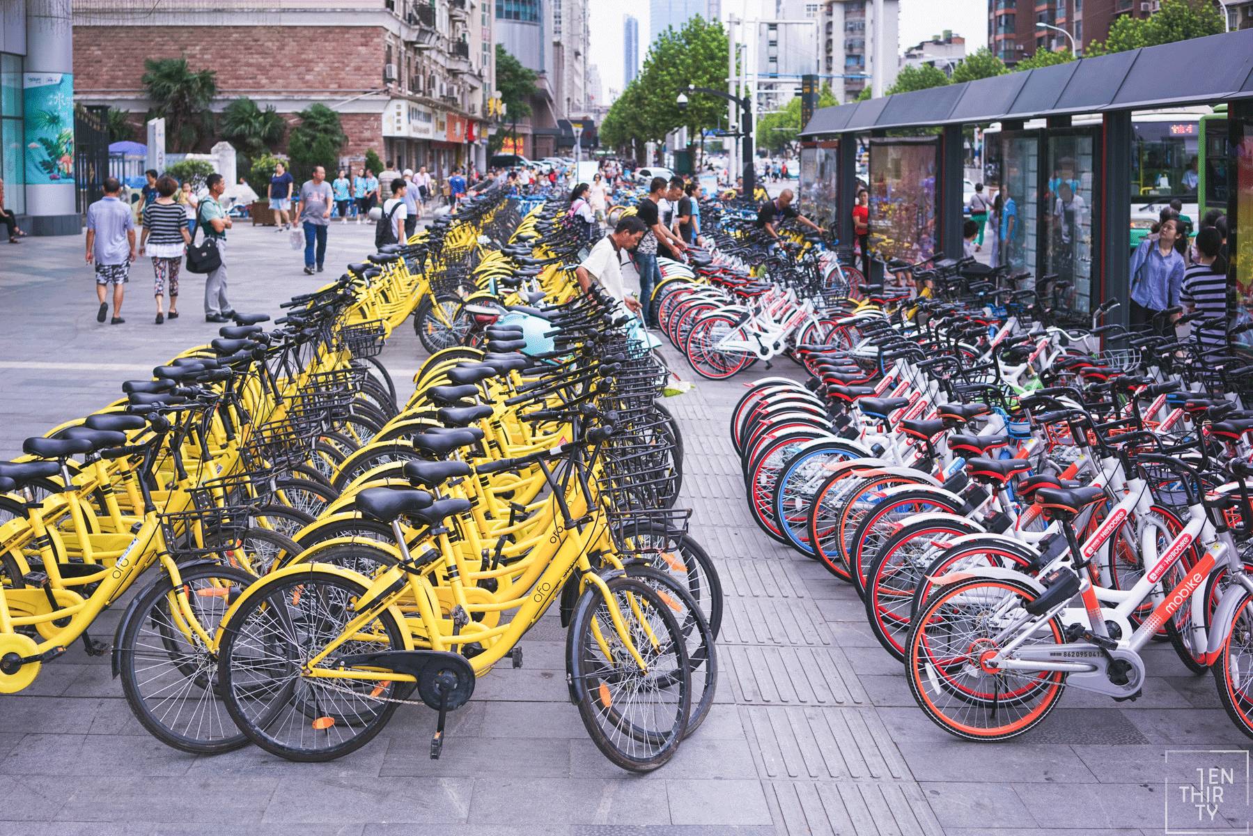 在武胜路地铁站口,有一群背着黑色书包学生模样的人在摆正共享单车