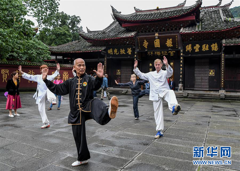 9月19日,峨眉山武术协会钟文华(前)在峨眉山报国寺门前教授俄罗斯游客