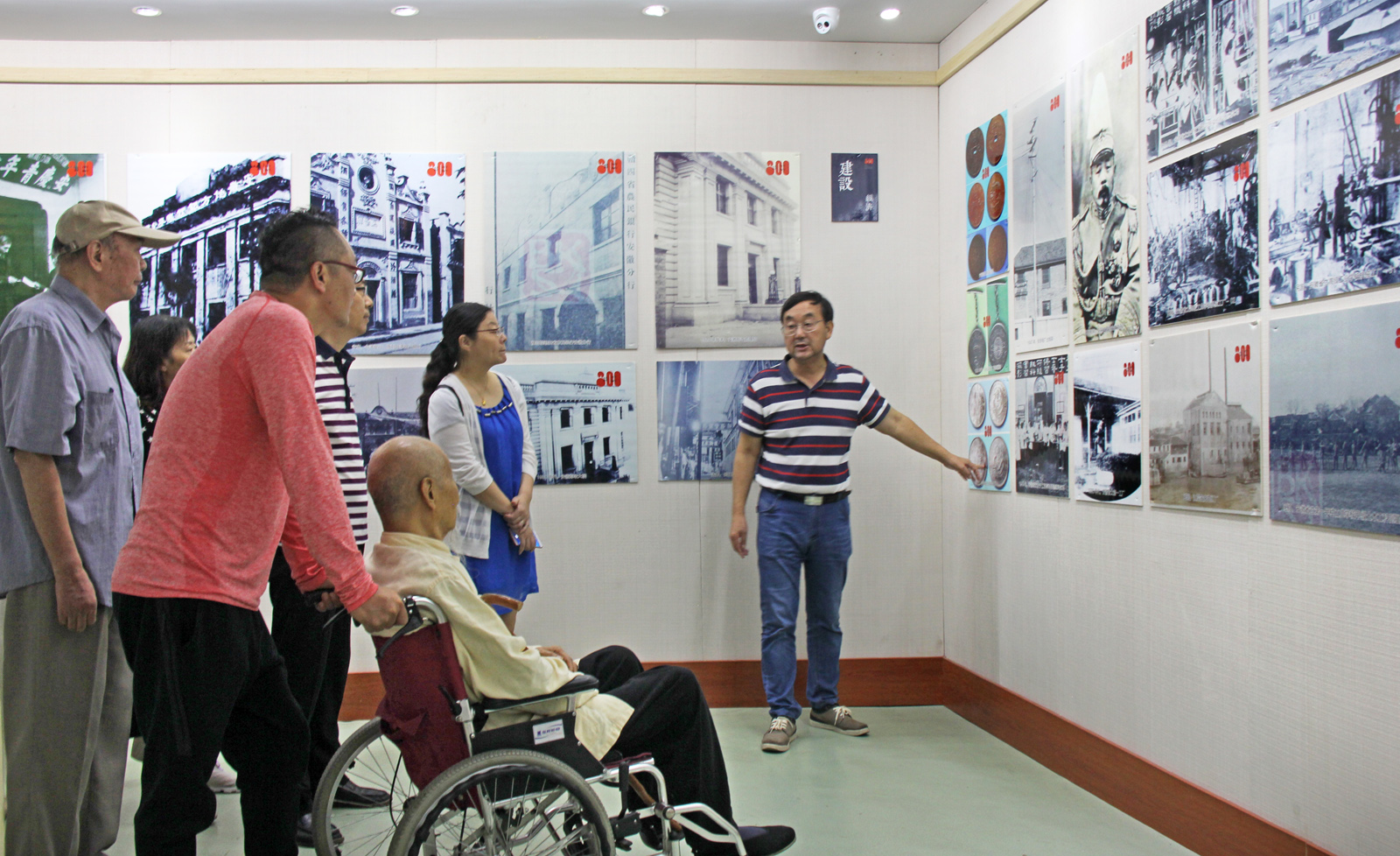 老城闲人在为国学导师邓松林老先生介绍图片展背景