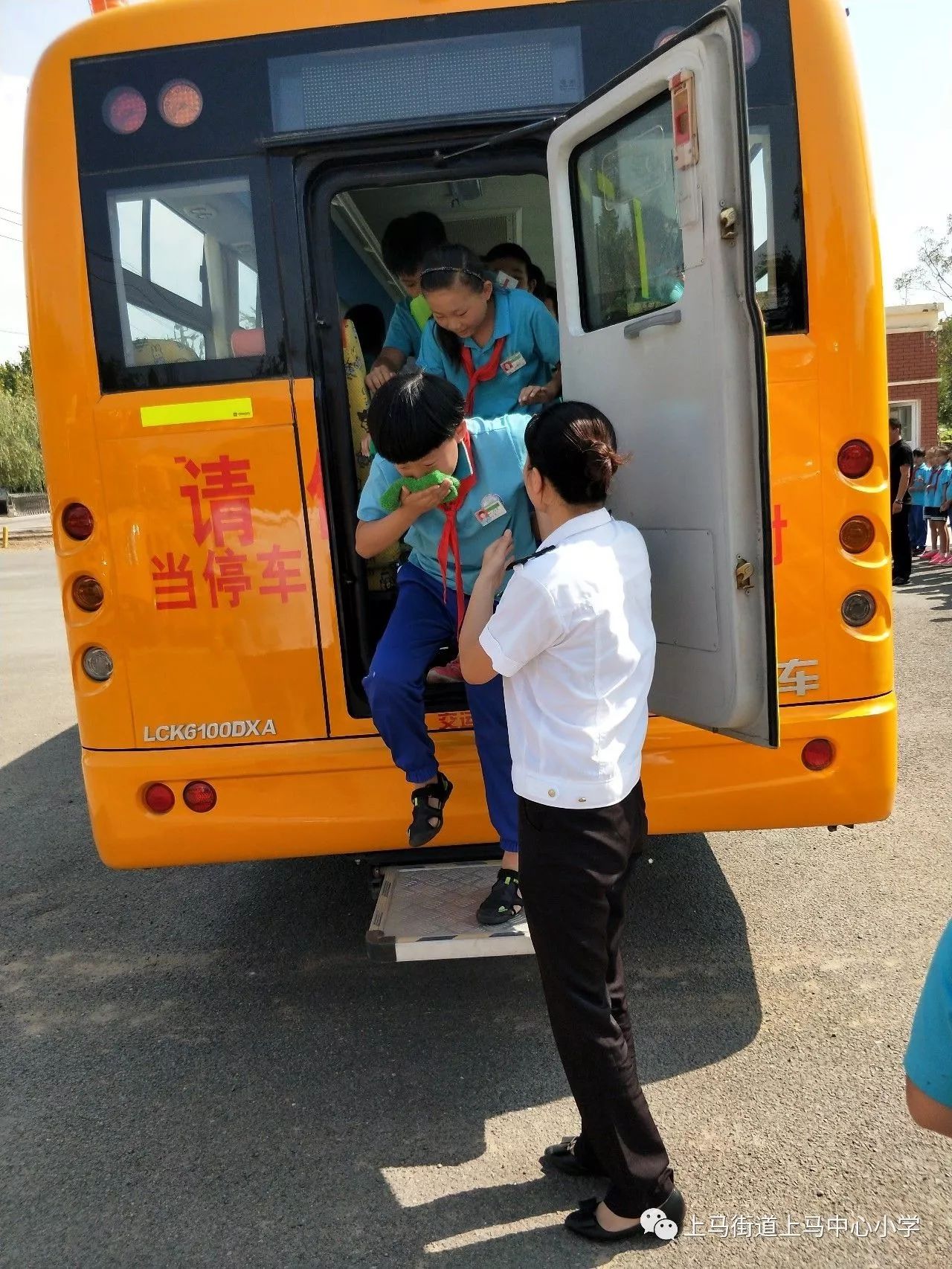 乘車學生在校車司機和照管員的組織下,迅速有序的從校車前後門下車