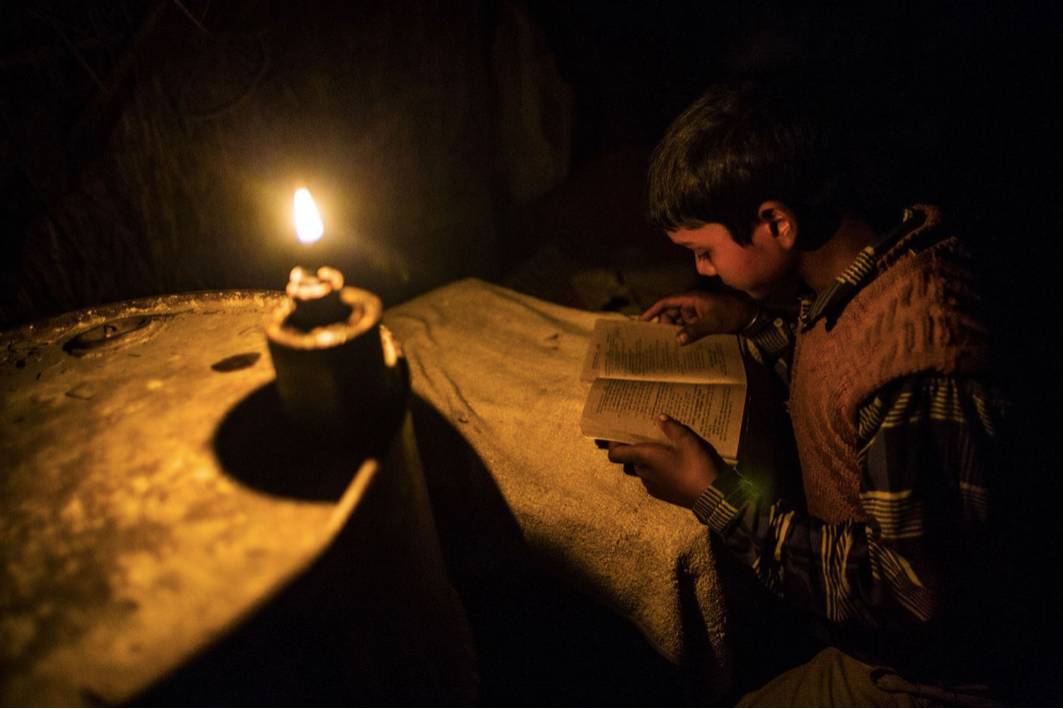 fateh nagla村里,一名男孩在煤油灯的照明下学习(图片来源:彭博社)