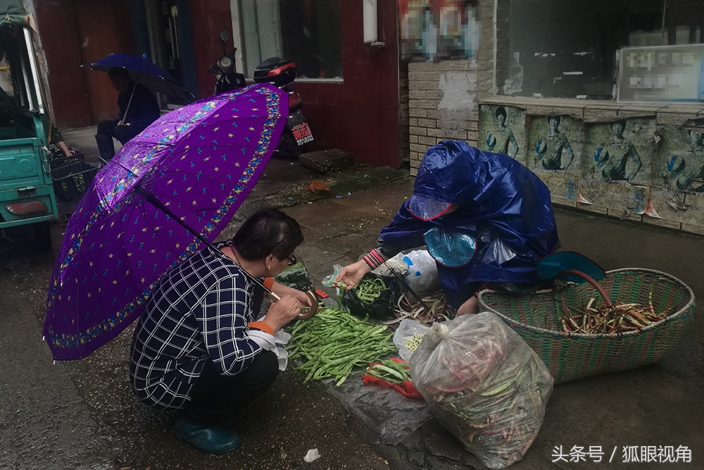 几位老人趁中秋节好行情在雨中街头卖菜说是为了多卖钱好买月饼