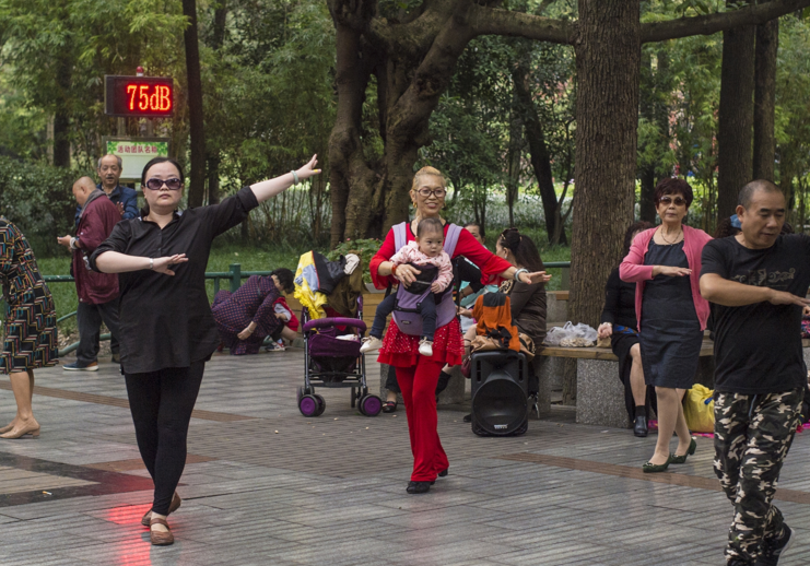 成都人民公园广场舞大妈大爷开启新技能,背着孩子一起尬舞!