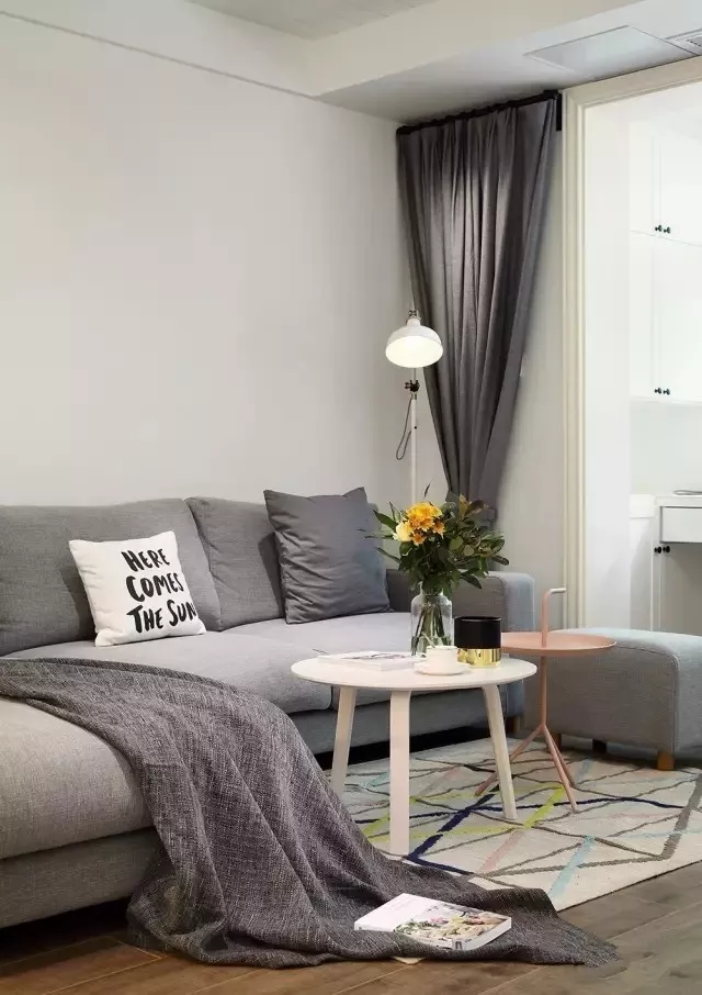 灰色的小转角沙发,搭配灰色窗帘,整体给人舒适干净的感觉